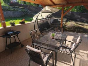 a patio with a table and chairs and an umbrella at Igali Kuckó in Igal