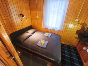 a small bed in a wooden room with a window at Igali Kuckó in Igal +15 photos