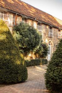 a brick building with bushes in front of it at Ferme du Roy in Anserville