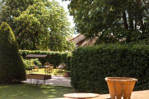 a garden with a bench and tables and a hedge at Ferme du Roy in Anserville +7 photos