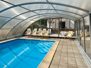 a swimming pool in a tent with chairs and a swimming pool at Brzozowa Zatoka Brenno in Brenno