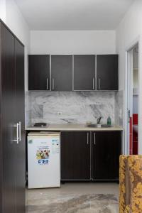 a kitchen with brown cabinets and a white refrigerator at Villa Elezi in Ulcinj