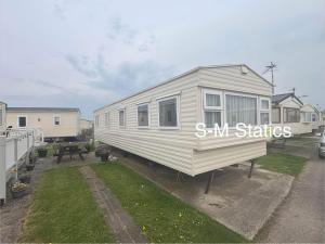 a tiny house is parked in a yard at S-M Statics in Kinmel Bay +1 photo