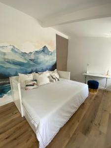 a bedroom with a white bed with a painting on the wall at Baionako extea in Bayonne