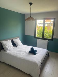 a bedroom with a bed with a stuffed animal on it at Au bon moment in Rang-du-Fliers