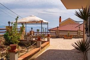 a patio with a gazebo and a building at Vickys Inn in Dhërmi