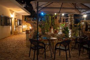 a restaurant with tables and chairs at night at Vickys Inn in Dhërmi