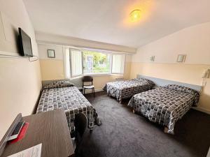 a hotel room with two beds and a table at Hôtel Saint Sébastien in Lourdes +21 photos