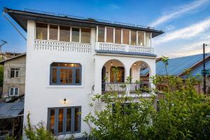 a white house with a balcony at Dar-e-Shafi in Srinagar