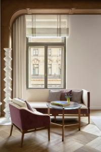 a living room with a couch and a table and a window at The St. Regis Budapest in Budapest