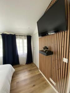 a bedroom with a tv on a wooden wall at Baionako extea in Bayonne