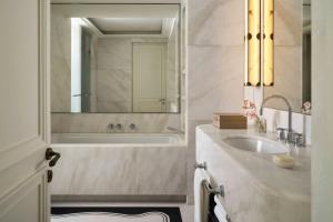 a bathroom with a tub and a sink and a mirror at The St. Regis Budapest in Budapest