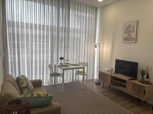 a living room with a couch and a table and a television at AnaSol2 in Esposende
