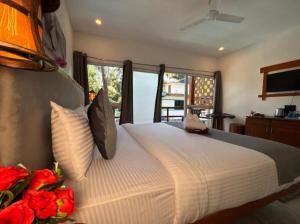 a bedroom with a large bed with red roses at White Turtle Resort in Morjim +6 photos