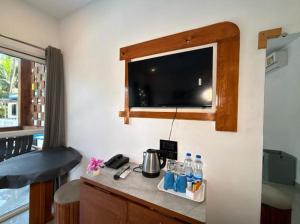a kitchen with a counter with a tv on the wall at White Turtle Resort in Morjim