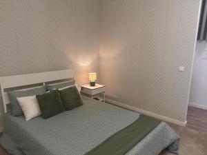 a bedroom with a bed and a lamp on a night stand at AnaSol2 in Esposende