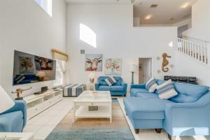 a living room with blue couches and a table at Orlando Theme Park Pool Homes in Kissimmee