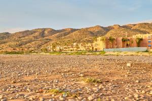 a rocky road with houses and mountains in the background at Hôtel Imi Plage in Agadir