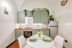 a kitchen with a white table and white chairs at Evergreen House in Cuneo