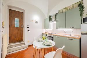 a kitchen with a white table and a small table and chairs at Evergreen House in Cuneo