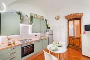 a kitchen with white cabinets and a white table at Evergreen House in Cuneo