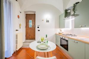 a kitchen with a white table and a white counter top at Evergreen House in Cuneo