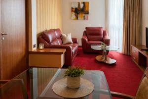 a living room with a couch and a chair at Hotel Bosna Banja Luka in Banja Luka