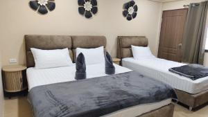 two beds in a room with hats on them at jdreamboxhostelpatong in Patong Beach