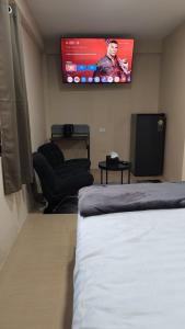 a room with a bed and a flat screen tv at jdreamboxhostelpatong in Patong Beach