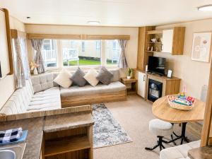a living room with a couch and a table at Golden Sands Getaways Weymouth in Wyke Regis