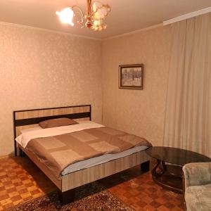 a bedroom with a bed and a table and a chandelier at Комнаты in Chişinău