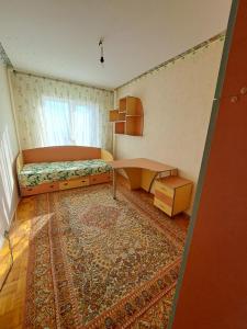 a bedroom with a bed and a table and a rug at Комнаты in Chişinău +4 photos