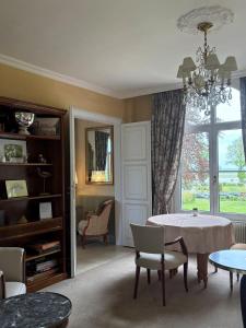 a living room with a table and chairs and a window at Château du Romerel - Baie de Somme in Saint-Valéry-sur-Somme