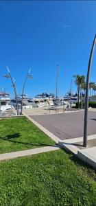 a park with a sidewalk and palm trees and a street at Studio Golfe Juan bord de mer - parking & piscine in Vallauris