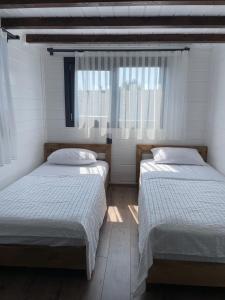 a bedroom with two beds and a window at Villa Maris in Demre