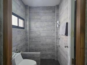 a bathroom with a toilet and a bath tub at Cocoa Hut in Mae Chan