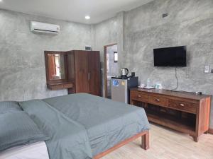 a bedroom with a bed and a television on the wall at Cocoa Hut in Mae Chan