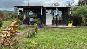 a small house with a chair in the yard at D's FarmStay in Kajiado