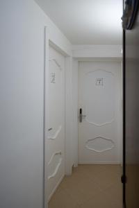 a hallway with a white door and a white wall at Quilungomare in Porto Cesareo