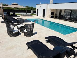 a group of chairs sitting next to a swimming pool at Villa DEL SOLE with Heated Saltwater Pool, Jacuzzi and Sauna in Ljubuški +61 photos
