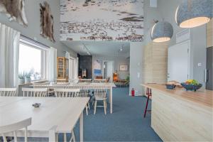a restaurant with white tables and chairs and a room at Hemavan Mountain Lodge Storfjället in Hemavan