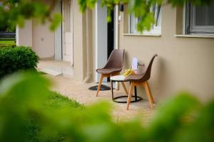 two chairs and a table next to a building at Coastal nest in Perea