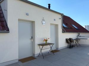 a white building with a door and a table on a patio at Apartmány u Zvonice in Kyjov