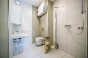a bathroom with a shower and a toilet and a sink at Apartia Urban Station in Brno