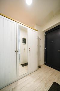 a bathroom with white cabinets and a black door at Apartia Urban Station in Brno