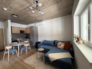 a living room with a blue couch and a table at Apartmány u Zvonice in Kyjov