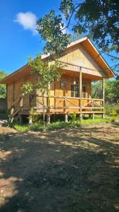 a large wooden house with a large porch at FRAPG camp and lodge in Mikumi