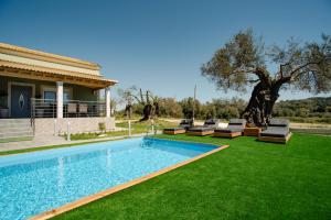 a swimming pool with lounge chairs and a house at Luxury Villa Kokos-Private Pool in a Serene Natural Private Estate in Vitalades