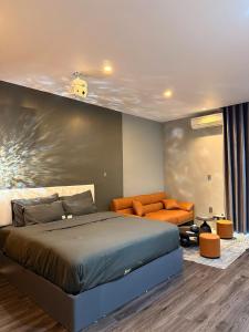 a bedroom with a bed and a couch at YourHome - Stay & More in Hoàng Mai