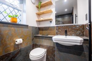 a bathroom with a sink and a toilet and a window at Potter's Wheel, by the lake in High Nibthwaite +24 photos
